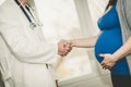 Handshaking between pregnant woman and doctor Royalty Free Stock Photo