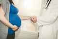 Handshaking between pregnant woman and doctor Royalty Free Stock Photo