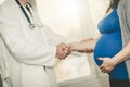 Handshaking between pregnant woman and doctor Royalty Free Stock Photo