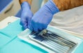 A portrait of the hands of a dentist opening a sterile bag with sterile tools. A bag contains a mouth mirror and cotton forceps Royalty Free Stock Photo