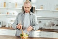 handsome adult man cooking vegetable salad Royalty Free Stock Photo