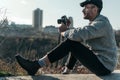 handsome adult man with vintage film camera sitting on rural road on sunny day Royalty Free Stock Photo