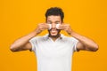 Handsome african american black man cleaning face skin with batting cotton pads over yellow background and looking at camera Royalty Free Stock Photo