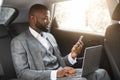 Handsome african businessman with laptop holding smartphone Royalty Free Stock Photo
