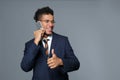 Handsome African-American businessman talking by mobile phone on grey background Royalty Free Stock Photo