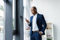 Handsome african american businessman talking on mobile phone in modern office. Royalty Free Stock Photo