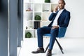 Handsome african american businessman talking on mobile phone in modern office. Royalty Free Stock Photo