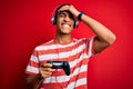 Handsome african american gamer man playing video game using jostick and headphones stressed with hand on head, shocked with shame Royalty Free Stock Photo