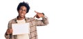 Handsome african american man with afro hair holding blank empty banner pointing finger to one self smiling happy and proud Royalty Free Stock Photo