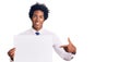 Handsome african american man with afro hair holding blank empty banner smiling happy pointing with hand and finger Royalty Free Stock Photo