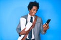 Handsome african american man with afro hair holding paper blueprints using smartphone smiling and laughing hard out loud because Royalty Free Stock Photo