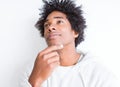 Handsome african american man with afro hair over white background with hand on chin thinking about question, pensive expression Royalty Free Stock Photo