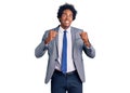 Handsome african american man with afro hair wearing business jacket excited for success with arms raised and eyes closed Royalty Free Stock Photo