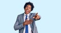 Handsome african american man with afro hair wearing business jacket laughing at you, pointing finger to the camera with hand over Royalty Free Stock Photo