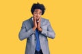 Handsome african american man with afro hair wearing business jacket tired hands covering face, depression and sadness, upset and