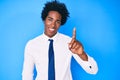 Handsome african american man with afro hair wearing business shirt and tie smiling with an idea or question pointing finger up Royalty Free Stock Photo