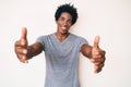 Handsome african american man with afro hair wearing casual clothes looking at the camera smiling with open arms for hug Royalty Free Stock Photo