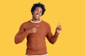 Handsome african american man with afro hair wearing casual clothes smiling and looking at the camera pointing with two hands and Royalty Free Stock Photo