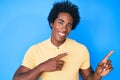 Handsome african american man with afro hair wearing casual clothes smiling and looking at the camera pointing with two hands and Royalty Free Stock Photo