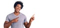 Handsome african american man with afro hair wearing casual clothes smiling and looking at the camera pointing with two hands and Royalty Free Stock Photo