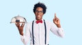 Handsome african american man with afro hair wearing waiter uniform holding silver tray surprised with an idea or question