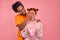 Handsome African American man covering his happy red haired Caucasian girlfriend eyes and giving her present small box Royalty Free Stock Photo