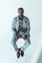 Handsome african american man in suit, sitting on a bar stool and looking at camera, Royalty Free Stock Photo