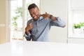 Handsome african american man on white table smiling confident showing and pointing with fingers teeth and mouth