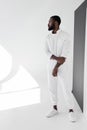 handsome african american man in white trendy clothes looking