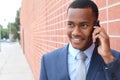 Handsome African American modern businessman walking in town and calling on mobile phone Royalty Free Stock Photo