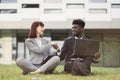 Handsome African businessman and caucasian businesswoman in gray suit shaking hands together Royalty Free Stock Photo