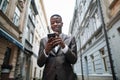 African man in suit standing on street with smartphone Royalty Free Stock Photo