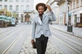 African guy in suit and hat smiling and walking on street Royalty Free Stock Photo