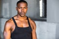 Handsome african male bodybuilding athlete, serious conviction and motivational determination against concrete background