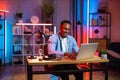 Handsome african man sitting at table and using laptop Royalty Free Stock Photo