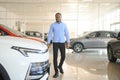 Handsome African man choosing a new car at the dealership Royalty Free Stock Photo