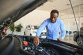 Handsome African man choosing a new car at the dealership Royalty Free Stock Photo