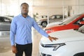 Handsome African man choosing a new car at the dealership Royalty Free Stock Photo