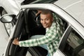 Handsome African man choosing new car at dealership Royalty Free Stock Photo