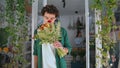 Handsome african man enjoy flowers in plant shop. Dreamy model look camera. Royalty Free Stock Photo