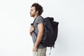 Handsome african man with rucksack standing in profile over white background. Royalty Free Stock Photo