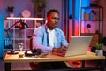 Handsome african man sitting at table and using laptop for work or studying Royalty Free Stock Photo