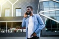 Handsome african man talking on phone at park. Young black man talking on cellphone outdoor. African american smiling guy in a Royalty Free Stock Photo