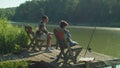 Caring African stepfather and cute boy bonding during fishing on lake