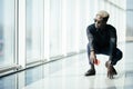 Handsome Afro American businessman in casual clothes and eyeglasses is holding mobile phone against panoramic windows on start pos Royalty Free Stock Photo