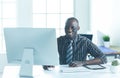 Handsome afro american businessman in classic suit is using a laptop and smiling while working in office Royalty Free Stock Photo