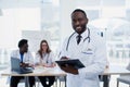 Handsome Afro American doctor in white coat is looking at camera and smiling. Young medical student with a stethoscope Royalty Free Stock Photo