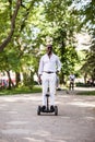 Handsome young afro american man rides on gyroscooter in the park.