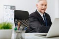 Handsome aged employer taking notes at the workplace