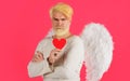 Handsome angel with valentines heart. Cupid man with white wings. Love concept.